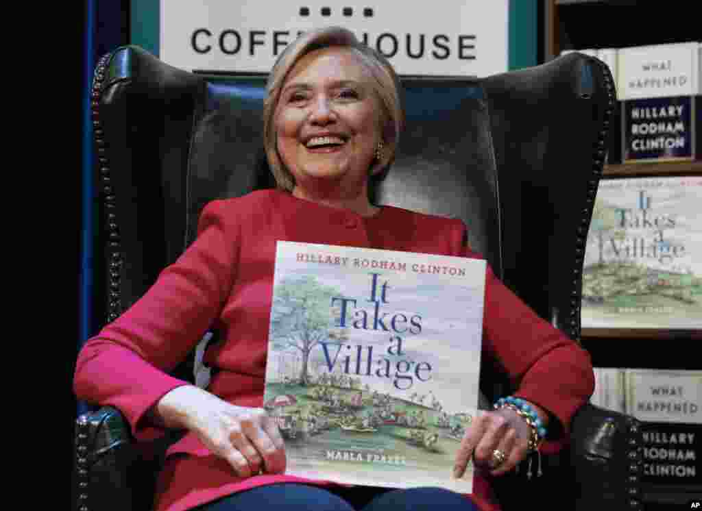 Hillary Clinton, tient son livre It Takes A Village lors de la présentation de son nouveau livre What Happened au Warner Theatre, Washington, 18 septembre 2017.