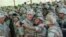 FILE - U.S. President George H. Bush holds a camera at arm's length for a self-portrait with Marines at Baidoa's airport, Jan. 1, 1993 in Baidoa. 