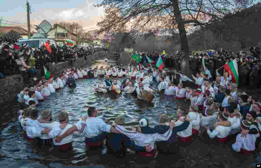 Bulgarians sing, play bagpipes and chain dance in the icy waters of the Tundzha river during Epiphany, in Kalofer. 