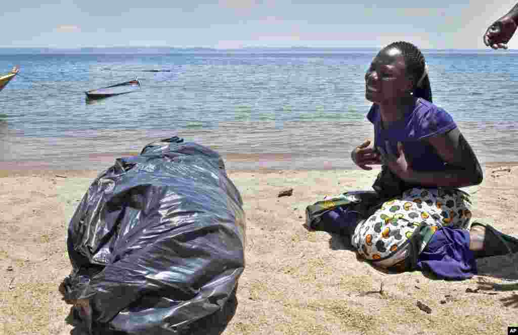 A woman cries next to the body of her sister, a victim of the MV Nyerere passenger ferry, as she awaits transportation for burial on Ukara Island, Tanzania, Sept. 22, 2018. The death toll soared past 200 while officials said a survivor was found inside the capsized ferry and search efforts were ending to focus on identifying bodies, two days after the Lake Victoria disaster.