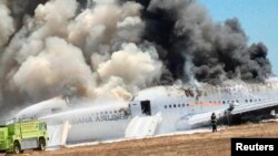 Pesawat Asiana Airlines Boeing 777 diselimuti asap setelah jatuh saat akan mendarat di bandar udara internasional San Francisco di California, 6 Juli. (Reuters/Eugene Anthony Rah)