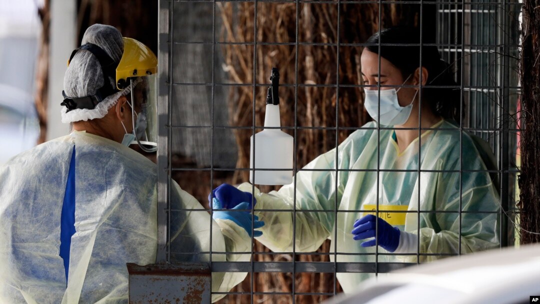 FILE - Medical staff prepare to take a COVID-19 tests at a drive through community based assessment center in Christchurch, New Zealand, Aug. 13, 2020.