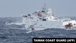 资料照片：台湾海警署2024年12月12日拍摄的照片显示，一艘台湾海警船(右)正在距离台湾东北海岸几海里处监视一艘中国海警船。