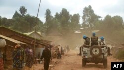 FILE - Soldiers from the U.N. mission in the Democratic Republic of Congo (MONUSCO) ride in a vehicle as they patrol in the violence-torn Djugu region, in Ituri province, eastern DRC, March 13, 2020.