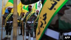 (FILE) Members of the Hezbollah brigades, Kata’ib Hizbollah, attend a funeral.