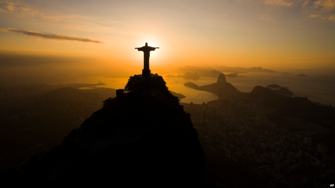 The sun rises behind the Christ the Redeemer statue, above the Guanabara bay in Rio de Janeiro, Brazil, July 19, 2016. 