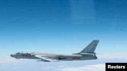 FILE - A Chinese military plane H-6 bomber flies through airspace between Okinawa prefecture's main island and the smaller Miyako island in southern Japan, photo taken Oct. 27, 2013.