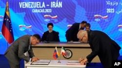 Con el presidente iraní Ebrahim Raisi y el presidente venezolano Nicolás Maduro sentados al fondo, los ministros de Petróleo de ambos países, el venezolano Pedro Rafael Tellechea, a la izquierda, y el iraní Javad Owji, firman un acuerdo en el palacio presidencial de Miraflores en Caracas, Venezuela, el lunes 12 de junio.  , 2023.