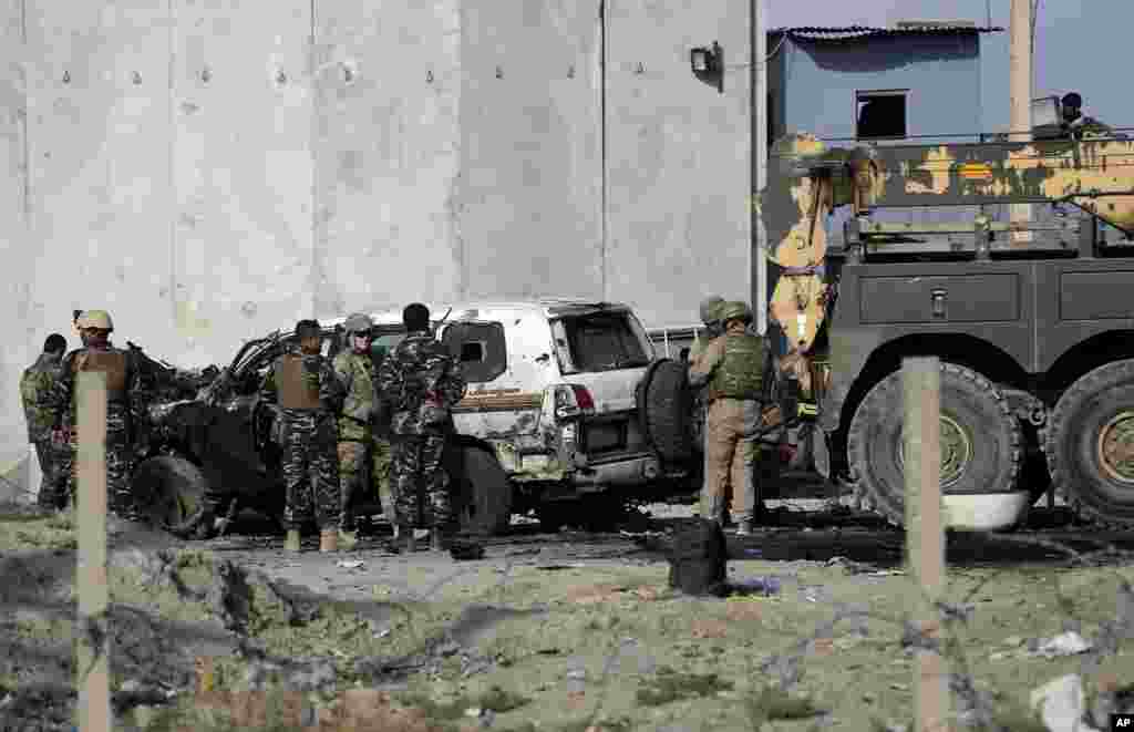 U.S. and Afghan security forces inspect the site of a suicide attack in Kabul, Monday, Oct. 13, 2014.