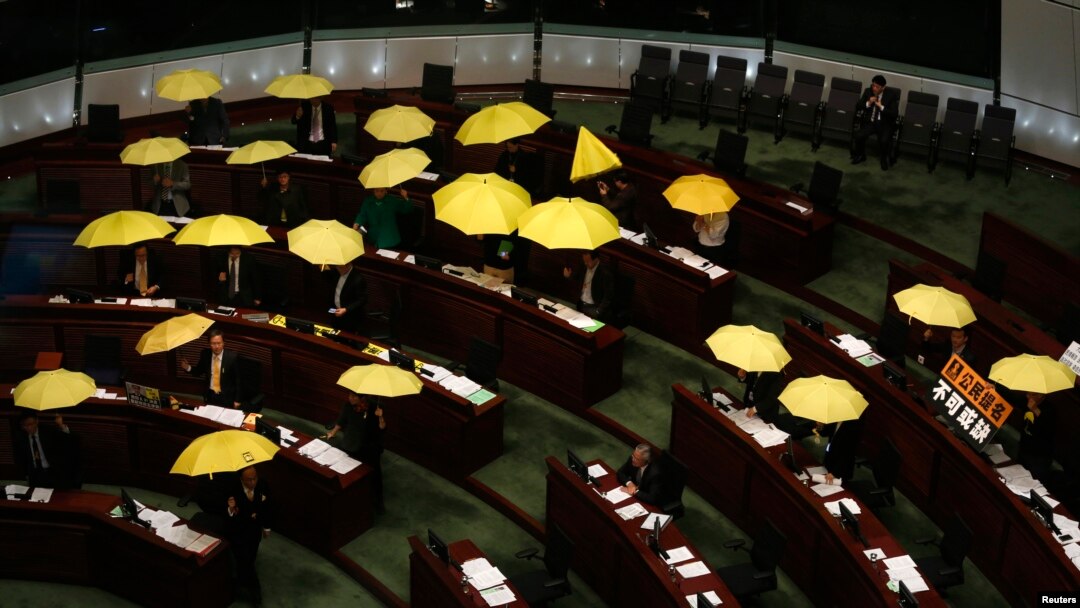 Para anggota parlemen pro-demokrasi membuka payung kuning - simbol solidaritas mereka - saat berlangsungnya rapat dewan legislatif di Hong Kong (7/1).