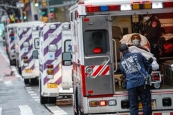 A patient arrives in an ambulance cared for by medical workers wearing personal protective equipment due to COVID-19 concerns outside NYU Langone Medical Center, April 13, 2020, in New York City.