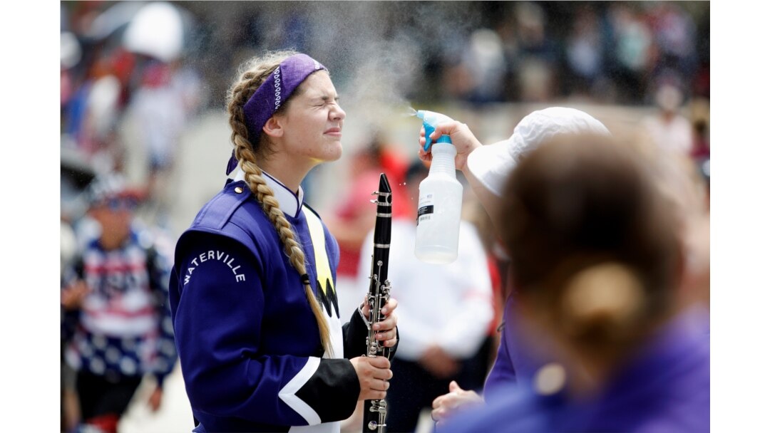 A member of the Waterville Junior/Senior High School marching band is sprayed with mist to prevent heatstroke while participating in a parade during Independence Day celebrations in Washington, July 4, 2019.