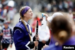 A member of the Waterville Junior/Senior High School marching band is sprayed with mist to prevent heatstroke while participating in a parade during Independence Day celebrations in Washington, July 4, 2019.