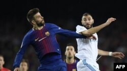 Le défenseur espagnol de Barcelone Gerard Pique et l'attaquant français du Real Madrid Karim Benzema lors d'un match au Camp Nou de Barcelone, le 6 mai 2018.