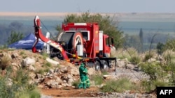 FILE - Rescuers cross the caution tape near a Metalliferous Mobile Rescue Winder during a rescue operation to retrieve illegal miners from an abandoned gold shaft in Stilfontein on Jan. 13, 2025.