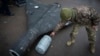 A Ukrainian officer shows a thermobaric charge of a downed Shahed drone launched by Russia in a research laboratory in an undisclosed location in Ukraine, Nov. 14, 2024. 