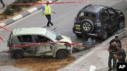 Israeli police engineers look at a camera as they examine the site after a rocket fired by Palestinian militants from the Gaza Strip hit the city of Ashdod. Israeli airstrikes killed Palestinian civilians and militants in the Gaza Strip, March 12, 2012.