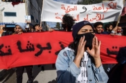Protesters march from the Ettadhamen city suburb on the northwestern outskirts of Tunisia's capital Tunis in a bid to reach an anti-government demonstration outside the Tunisian Assembly headquarters, Jan. 26, 2021.