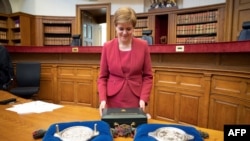 Scottish National Party (SNP) Leader Nicola Sturgeon poses with the Seals of Scotland after being sworn in as Scotland's First Minister during a ceremony at the Court of Session in Parliament Hall in Edinburgh, May 19, 2021. 