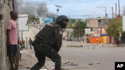 Un policía observa durante un intercambio de disparos entre pandillas y policías en Puerto Príncipe, Haití, el lunes 11 de noviembre de 2024.