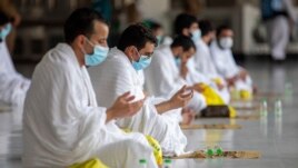 In this photo released by the Saudi Media Ministry, a limited numbers of pilgrims pray in the first rituals of the hajj, as they keep social distancing to limit exposure and the potential transmission of the coronavirus, at the Grand Mosque