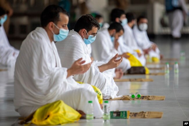 Sejumlah jamaah haji berdoa dalam ritual pertama haji dengan menjaga jarak sosial untuk membatasi paparan dan potensi transmisi virus Covid-19, di Masjidil Haram, Mekkah, Arab Saudi, Rabu, 29 Juli 2020. (Saudi Media Ministry via AP)