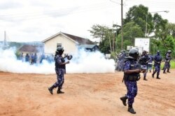 Ugandan riot policemen fire tear gas canisters to disperse supporters of presidential candidate Robert Kyagulanyi, also known as Bobi Wine, in Luuka district, eastern Uganda, Nov. 18, 2020.