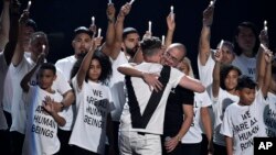 Ryan Tedder of One Republic, left, and Logic embrace after performing "One Day" onstage at the MTV Video Music Awards at Radio City Music Hall on Monday, Aug. 20, 2018, in New York.