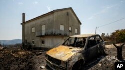 A burnt car is seen following a fire near Roda, in central Portugal on July 23, 2019. Emergency services in Portugal have brought under control a huge wildfire which raged for four days and injured 39 people.