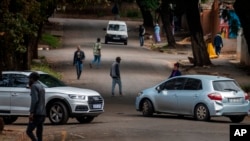 FILE - Few cars and residents are seen in the normally busy streets of Yeoville, downtown Johannesburg, South Africa, April 10, 2020. 