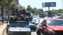 Sebuah keluarga asal Suriah duduk dengan barang bawaan mereka di atas sebuah pikap di Kota Sidon di Lebanon, pada 23 September 2024. (Foto: AFP/Mahmoud Zayyat)