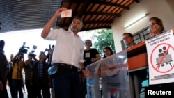 Paraguay's President Mario Abdo shows a ballot before casting his vote during Paraguay's general election, in Asuncion, Paraguay April 30, 2023.