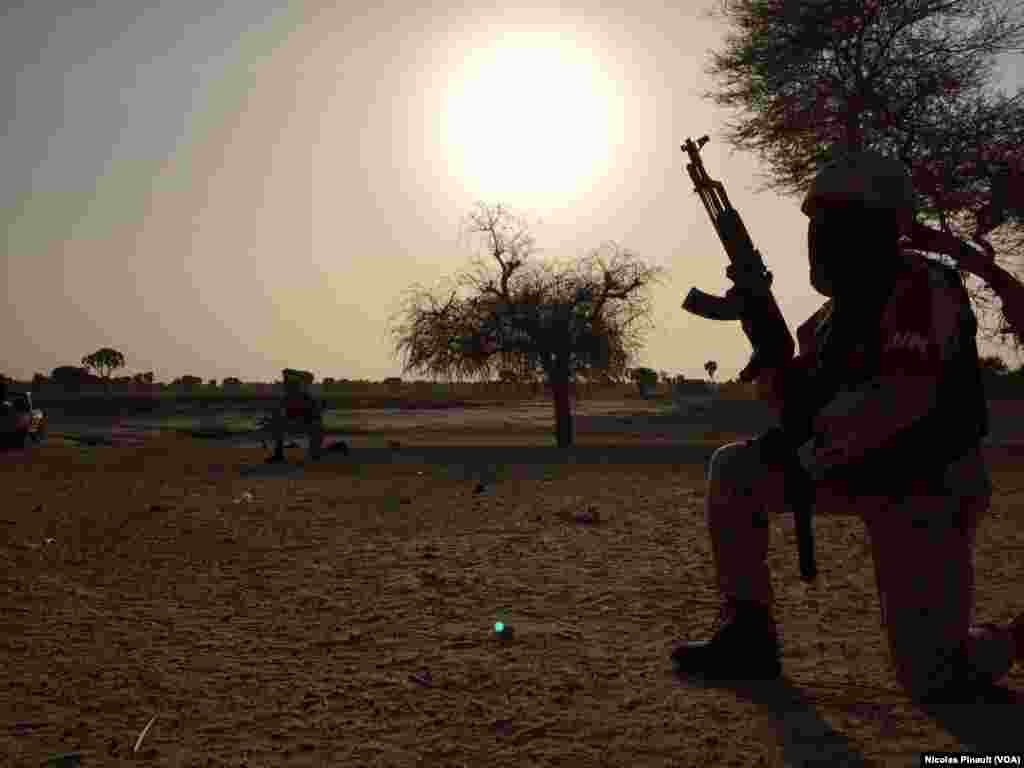 Un soldat de la garde nationale nigérienne surveille l'horizon dans le village de Zenam Kelouri, le 29 février 2016. (VOA/Nicolas Pinault)