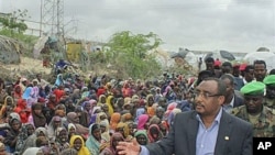 Somali prime minister Abdiwali Mohamed Ali (R) visits the largest displaced persons camp in Mogadishu, to assess the scale of drought victims flooding into the capital of Mogadishu, July 26, 2011