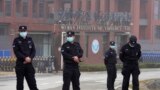 Security personnel gather near the entrance of the Wuhan Institute of Virology during a visit by the World Health Organization team in Wuhan in China's Hubei province on Wednesday, Feb. 3, 2021. 