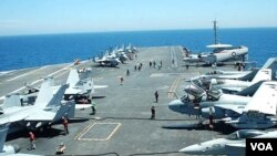 Pesawat-pesawat tempur AS disiagakan di landasan terbang kapal induk USS George Washington, dalam latihan militer Senin 26 Juli 2010.