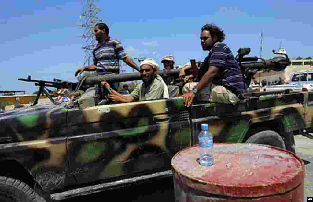 Rebel fighters speed towards the frontllne fighting in the village of Mayah, some 30 kilometers west from Tripoli, Libya, Aug. 21, 2011. (Sergey Ponomarev/AP)