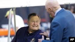 FILE - Former President George H.W. Bush talks with Houston Texans owner Bob McNair before a National Football League game between the Texans and the Cincinnati Bengals in Houston, Nov. 23, 2014.