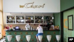 FILE - In this Sept. 12, 2017, file photo, a customer sits at the lobby bar of the Hotel Capri in Havana, Cuba. Doctors are releasing the first detailed medical reports about the hearing, vision, balance and brain symptoms suffered in what the State Department has called “health attacks” on U.S. diplomats in Cuba.