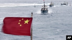 Chinese fishing boats sail in the lagoon of Meiji reef off the island province of Hainan in the South China Sea, July 20, 2012.