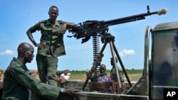 FILE - Government soldiers stand guard by their vehicle on the front lines in the town of Kuek, northern Upper Nile state, South Sudan, Aug. 19, 2017