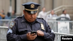 A New York City Police Department (NYPD) sergeant uses his mobile phone while on duty in lower Manhattan in New York City, US, May 25, 2016. 