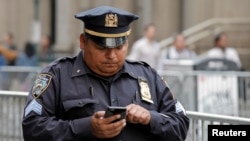 New York'ta akıllı telefonunu kullanan bir polis memuru