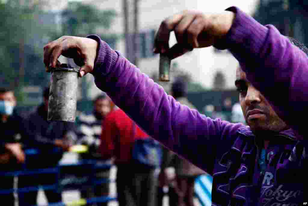A protester on near Tahrir Square holds a spent shotgun shell and a tear gas canister. (VOA - Y. Weeks)