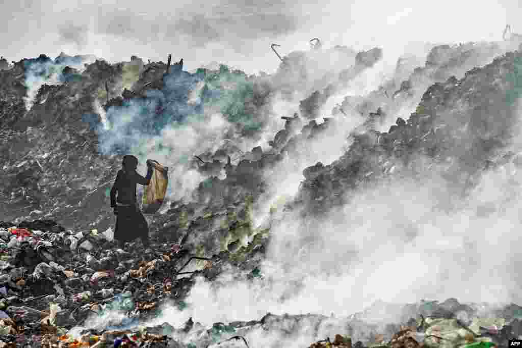 A boy sifts through a garbage dump near an oil field in the countryside of Malikiya in northeast Syria.