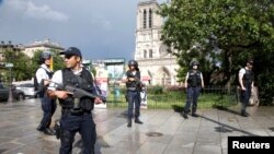 Polisi Perancis mengamankan lokasi serangan di dekat Katedral Notre Dame di Paris, Selasa (6/6).