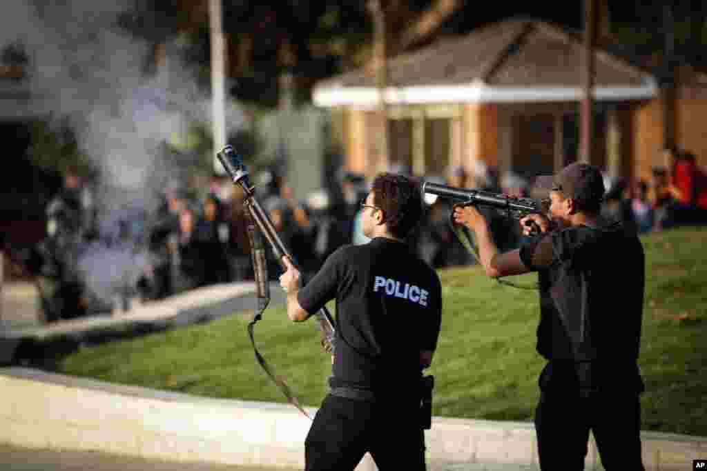 Egyptian security forces fire tear gas to disperse students and supporters of the country's ousted president after they rallied outside a Cairo university, Thursday, Nov. 28, 2013.