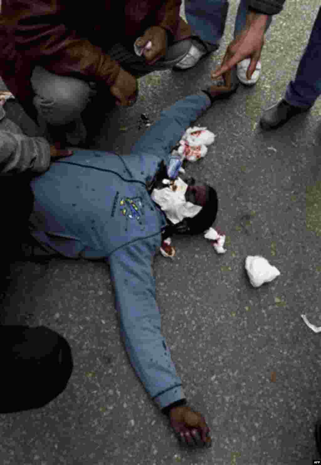 An injured anti-government protester lies on the ground as he is treated by medics during clashes in Tahrir, or Liberation square, in Cairo, Egypt, Wednesday, Feb. 2, 2011. Several thousand supporters of President Hosni Mubarak clashed with anti-governmen