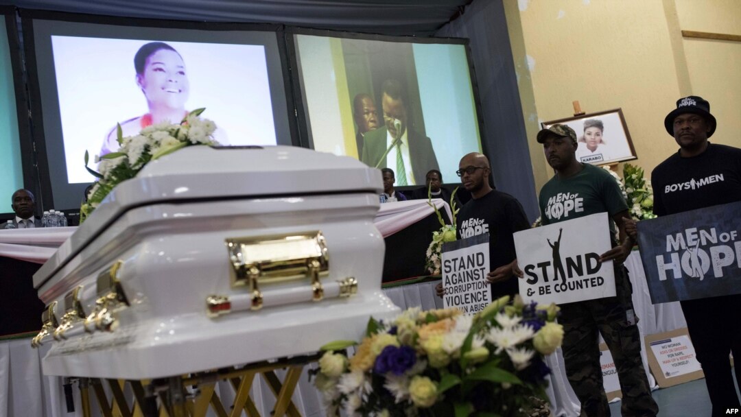 South African men hold placards denouncing violence against women during the memorial service for Karabo Mokoena in Johannesburg, South Africa, May 19, 2017. 