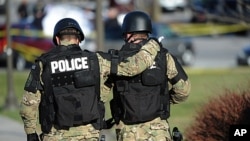 Virginia Tech police officers console one another as they move toward the scene where a fellow police officer was killed in a parking lot on the campus of Virginia Tech in Blacksburg, Virginia, December 8, 2011.